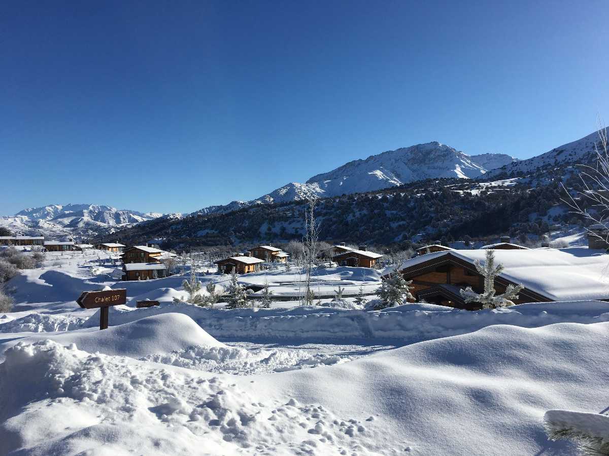 Zomin Ropeway in Uzbekistan - a snow covered village with mountains in the background.