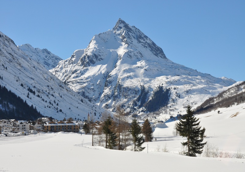 Austrian chalet amidst a scenic mountain landscape at Galtuer – Silvapark in Tiroler Oberland, Tyrol. The winter surroundings embellish a bustling ski resort depicting an exciting winter sports scene.