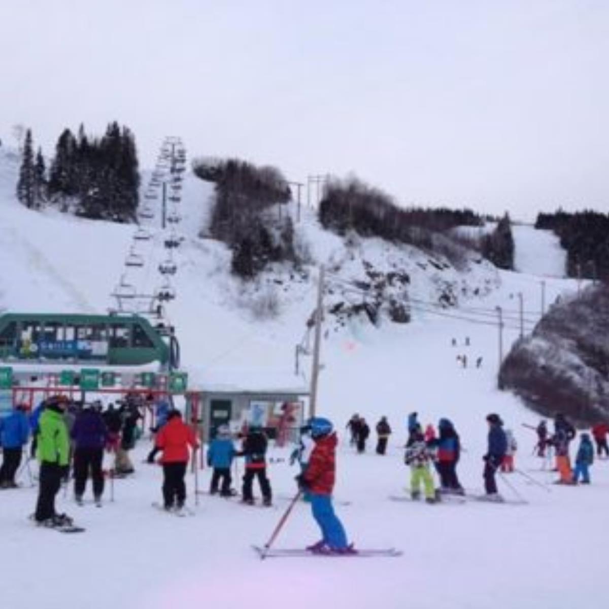 Mont Ti-Basse in Canada - a group of people skiing down a snowy slope.