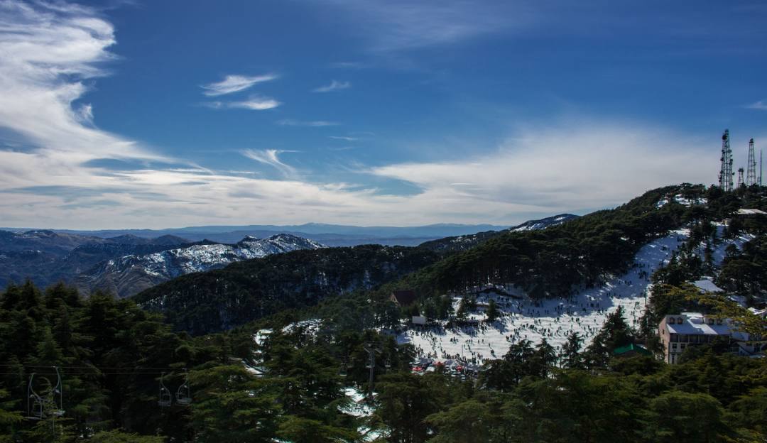 A charming chalet nestled in the snowy landscape of Chréa, Blida, Algeria. The stunning winter scenery exhibits peaking mountains and hints at winter sports activities.