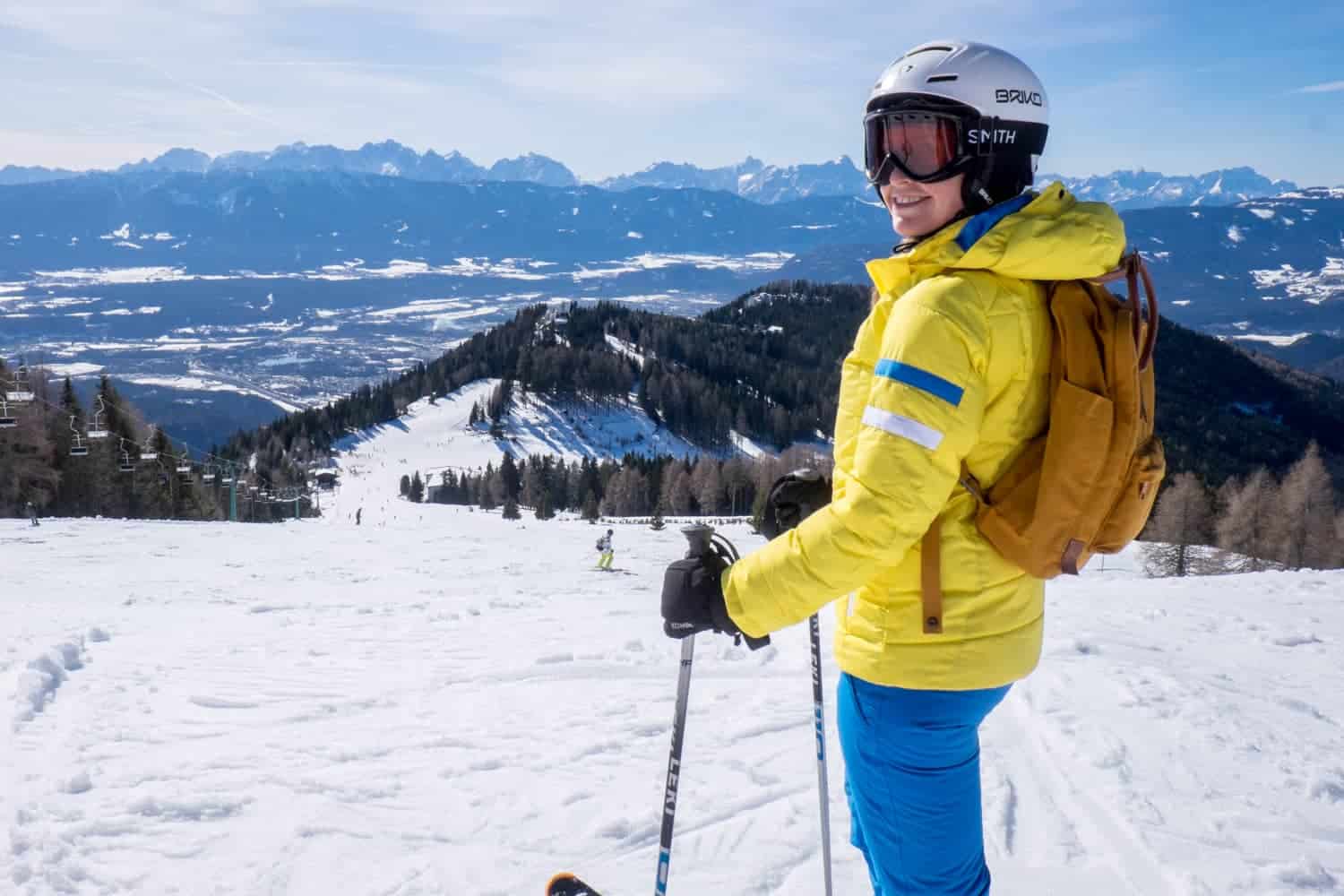 Gerlitzen Alpe in Austria - a woman in a yellow jacket and blue pants on skis.
