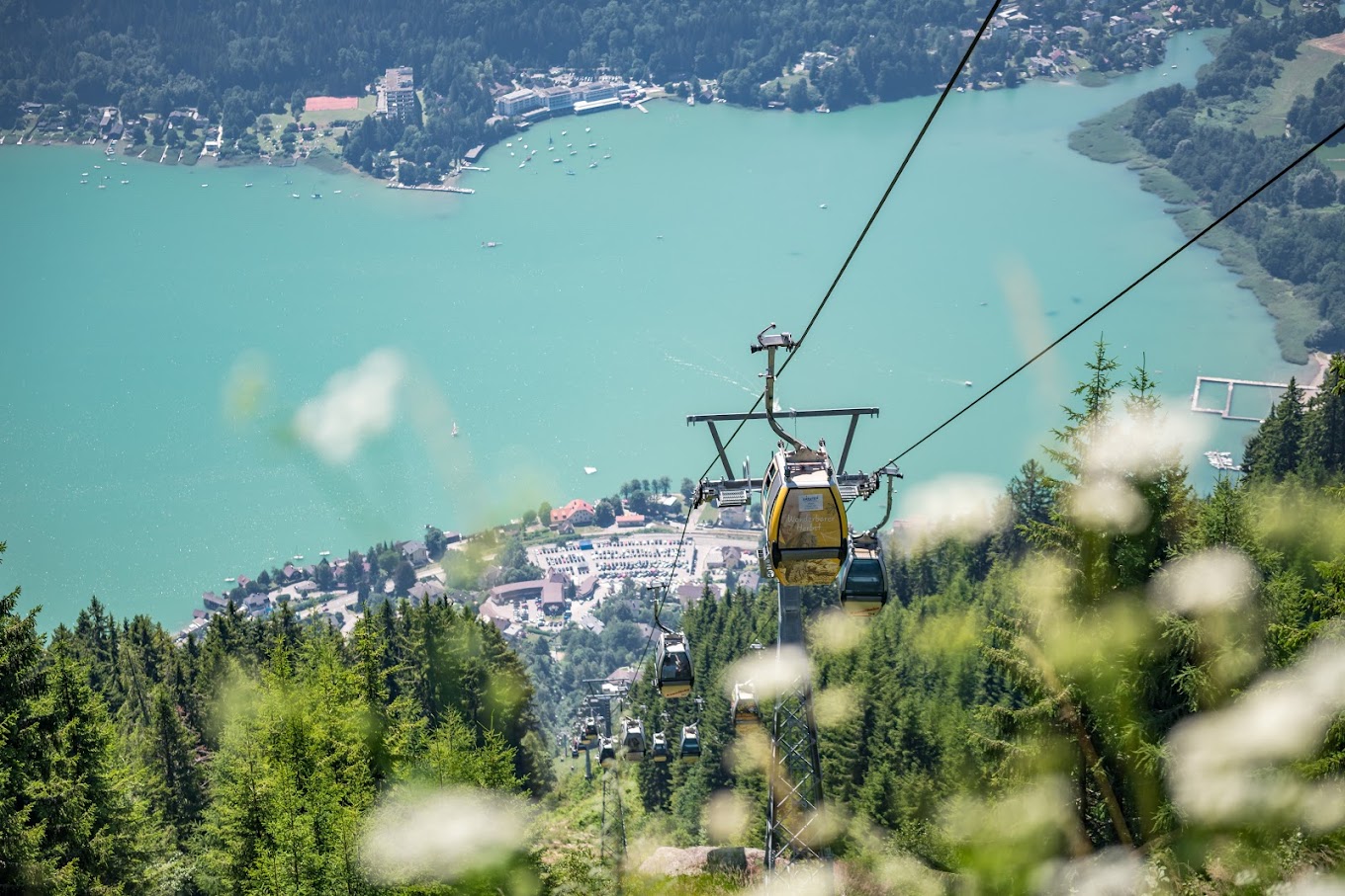 Gerlitzen Alpe in Austria - a cable car going up a mountain with a lake in the background.