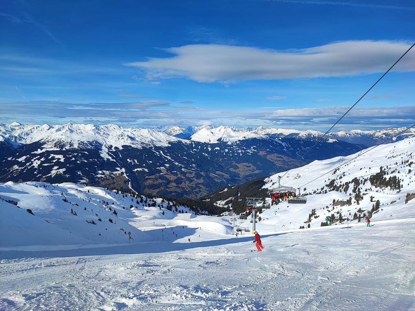 Zillertal Arena – Zell am Ziller | Gerlos | Königsleiten | Hochkrimml in Austria - a person on a ski lift going down a snowy slope.