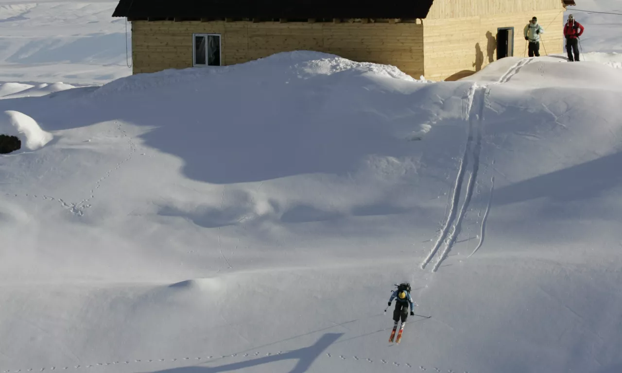 Too Ashuu Ski base in Kyrgyzstan - a group of people skiing down a snowy hill.