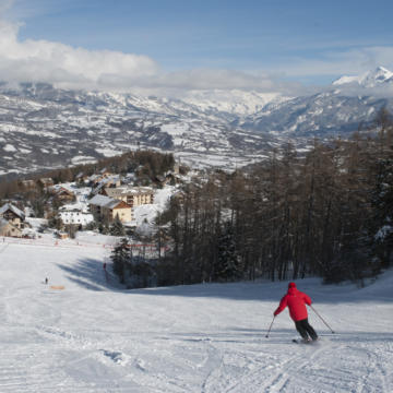Scenic view of Laye ski resort in France showcasing a vibrant winter sports scene. Skiers are seen enjoying the slopes near a charming chalet. Perfect for winter sport enthusiasts.