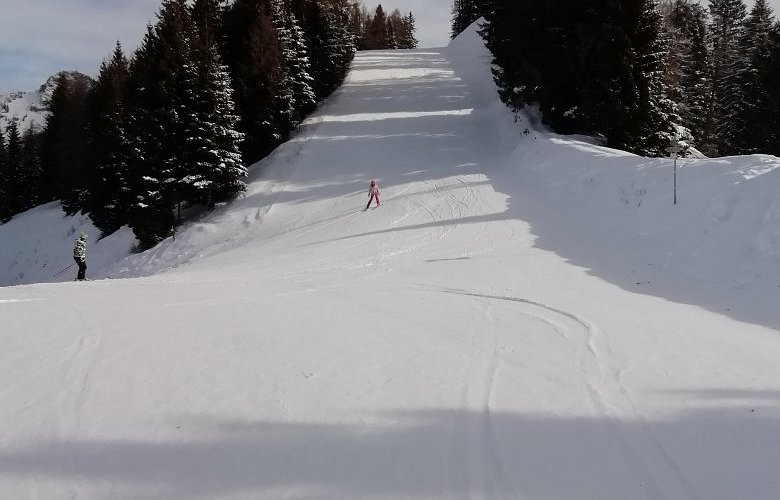 A skier gliding down snowy slopes amid chalets in Piazzatorre a charming ski resort in Lombardy Italy. The winter sports centre contributes to the lively winter sports scene.