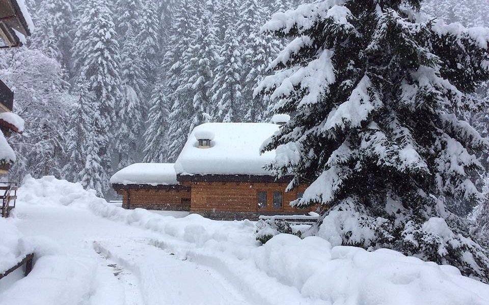 View of a mountain hut, lodge, and chalet in the serene winter setting of Piazzatorre in Lombardy, Italy. The area is known for its winter sports activities.