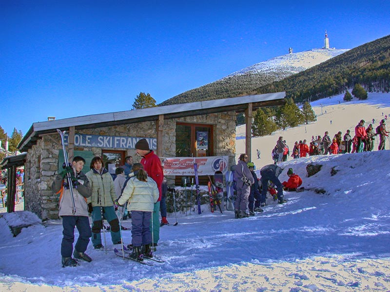 Scenic view of Mont Serein ski resort in France showcasing a bustling winter sports scene a ski lift and a quaint chalet in the snowy landscape.