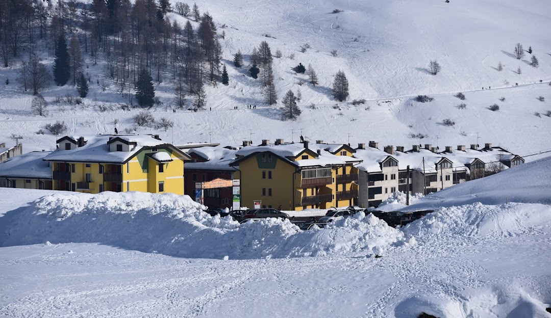 Scenic view of Malga San Giorgio ski resort in Venetia, Italy. A charming chalet and winter sports center amidst snowy Alpine landscape, presenting an idyllic winter sports scene.