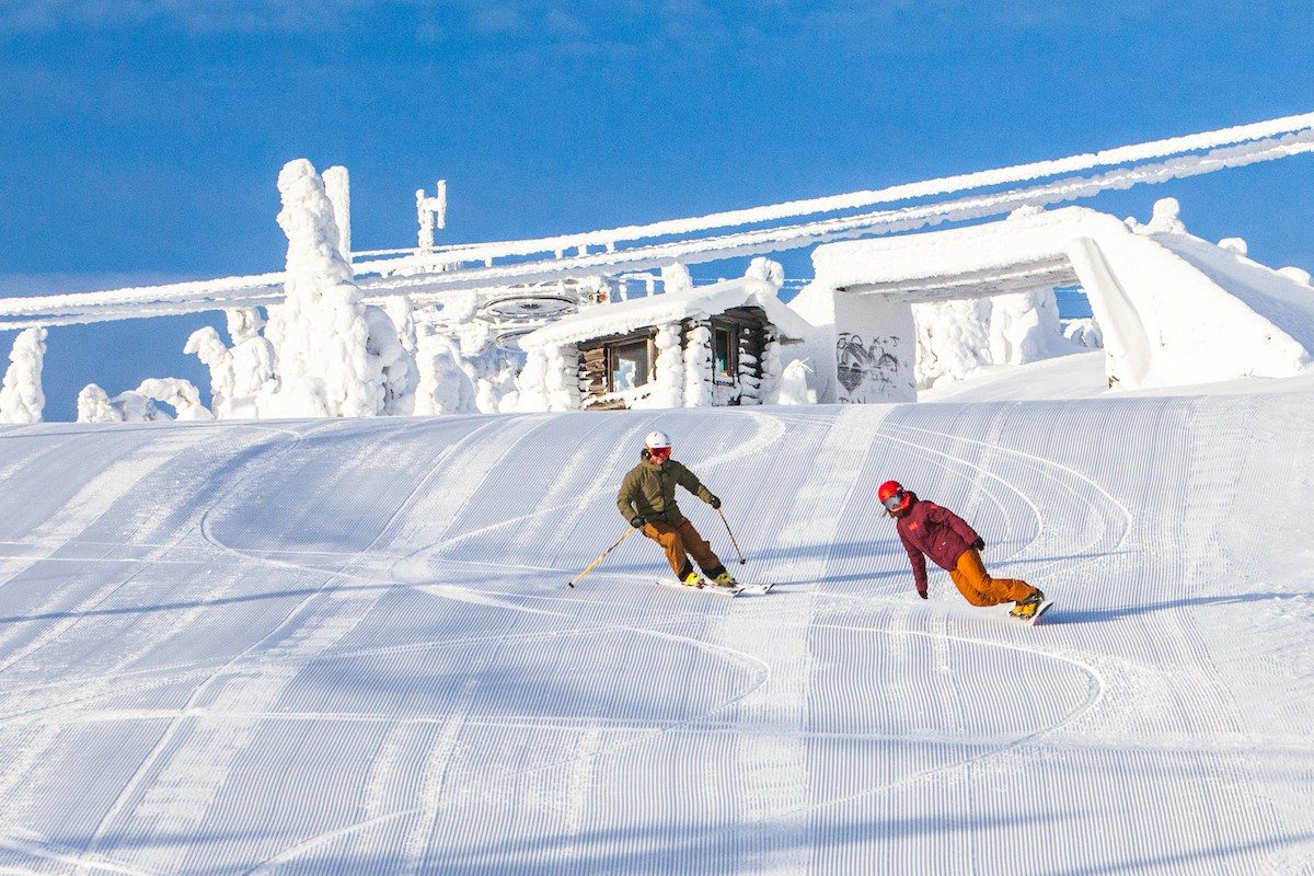 Iso-Syöte in Finland - two people skiing down a snow covered slope.