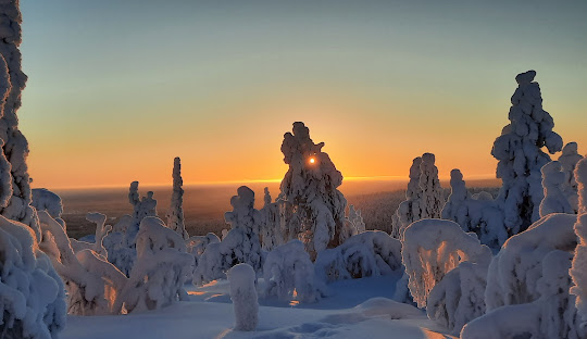 Winter scene at Iso-Syöte, Varpuperä, Finland, showcasing a stunning winter landscape, a ski resort nestled in the mountains, and winter sports enthusiasts in action.