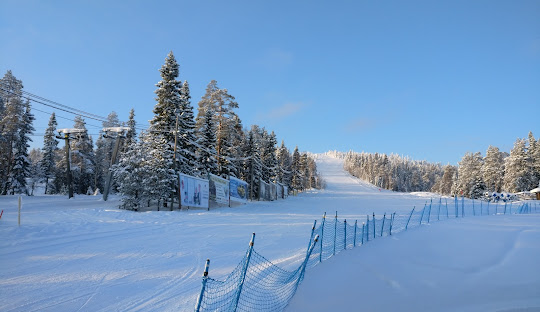 A captivating winter scene at Iso-Syöte ski resort in Northern Finland showcasing skiers enjoying the pristine slopes amidst a stunning snow-covered landscape.