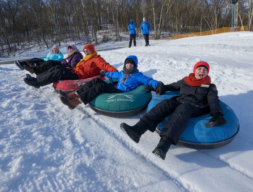 Perfect North Slopes in USA - a group of children sling down a hill.