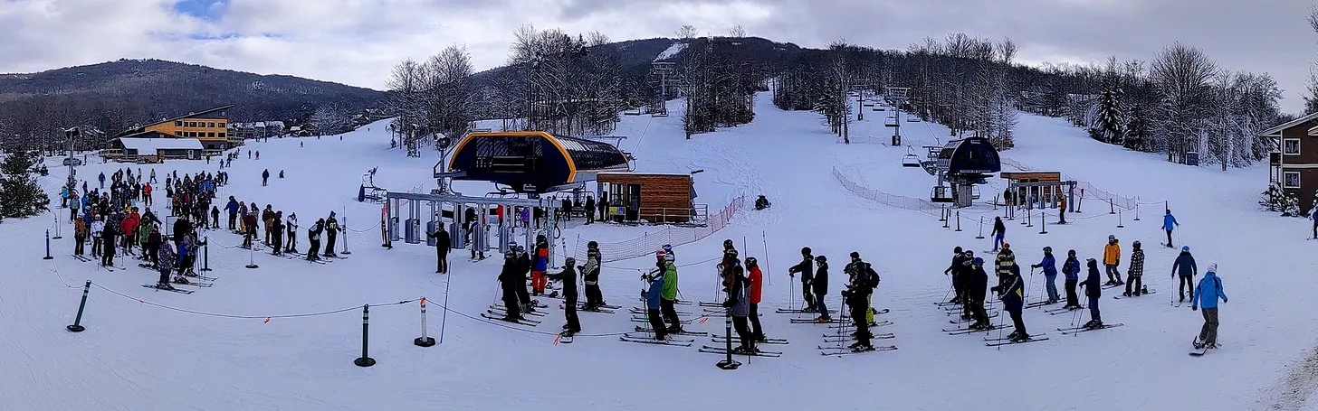 Perfect North Slopes in USA - a group of people standing on top of a snow covered slope.