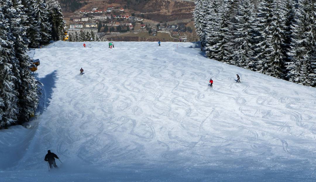 A scenic view at Perfect North Slopes ski resort in Lawrenceburg Indiana featuring a skier in action the winter sports center and a chalet all enveloped in a winter sports scene.