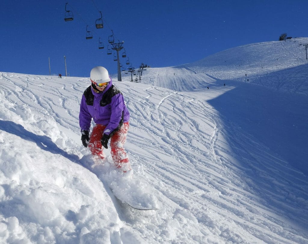 Skálafell in Iceland - a person riding a snowboard down a snowy slope.