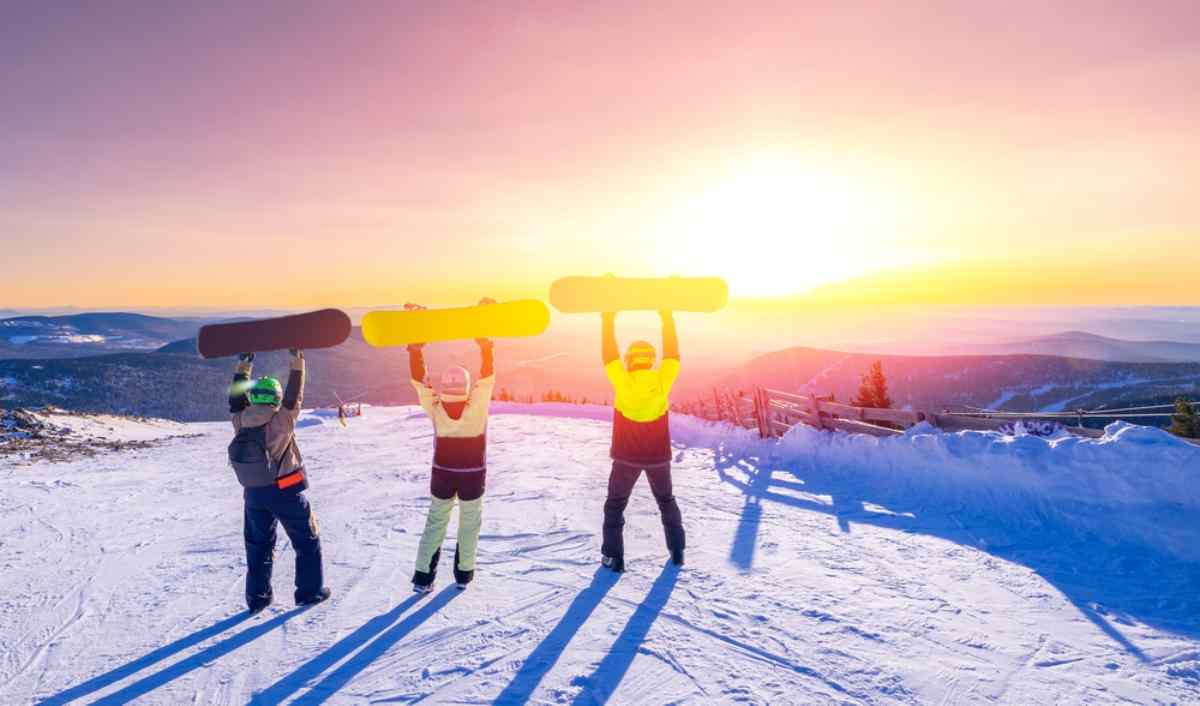 Skálafell in Iceland - two people holding ski boards on top of a mountain.