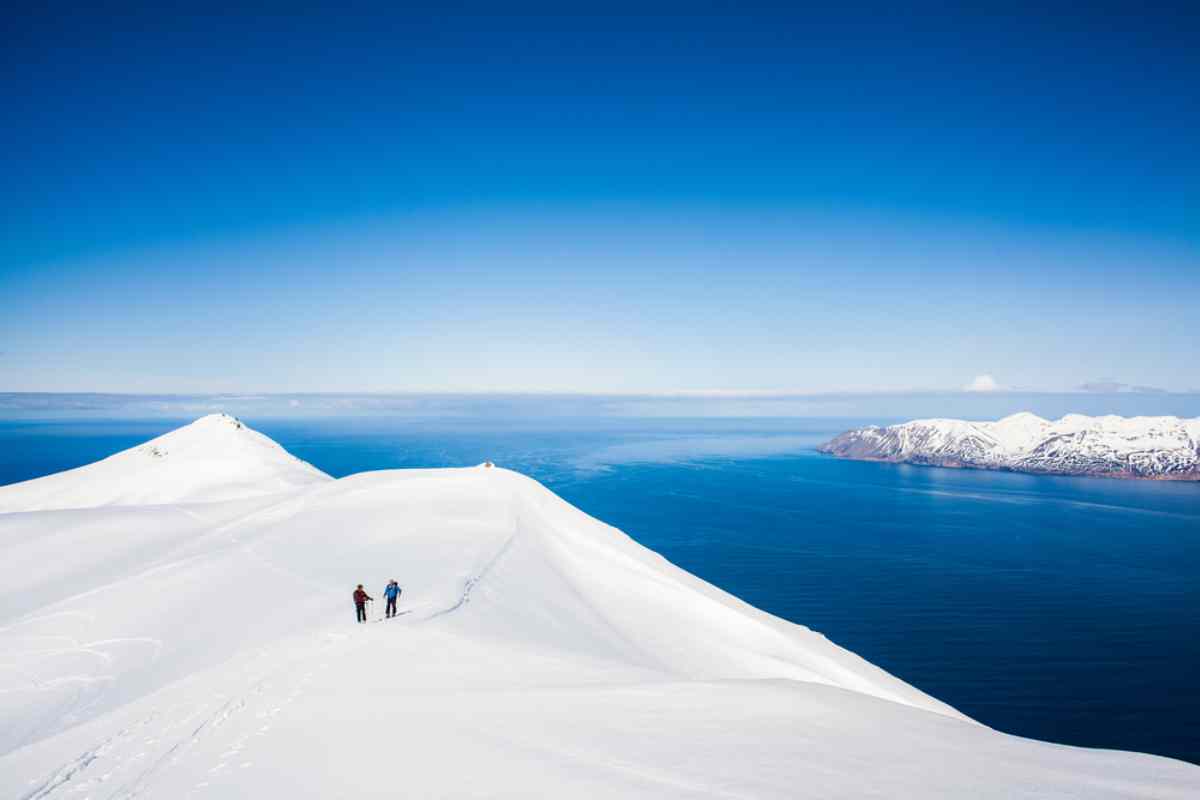Skálafell in Iceland - two people standing on top of a snowy mountain.