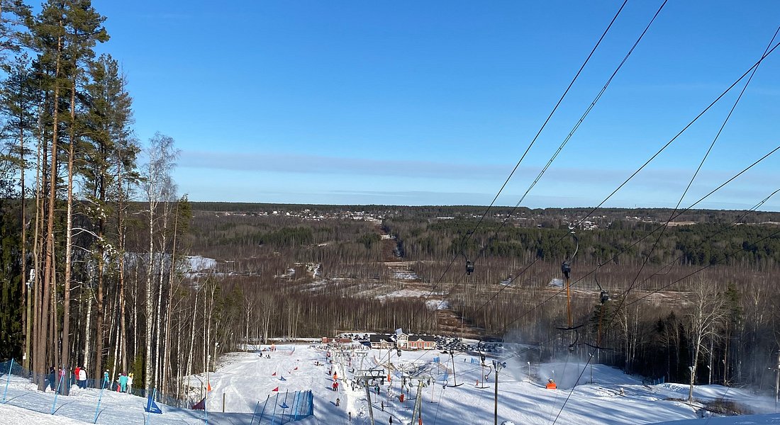 Winter scene at Krasnoye Ozero ski resort in Northwest Russia, featuring a ski lift with skiers enjoying the snowy slopes.
