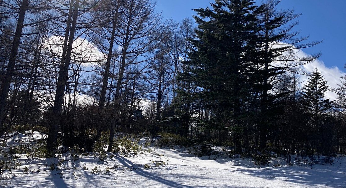 Stunning winter scene at Chateraise Ski Valley Koumi in Japan, featuring a cozy chalet set against a backdrop of snow-covered mountains and skiers enjoying winter sports.