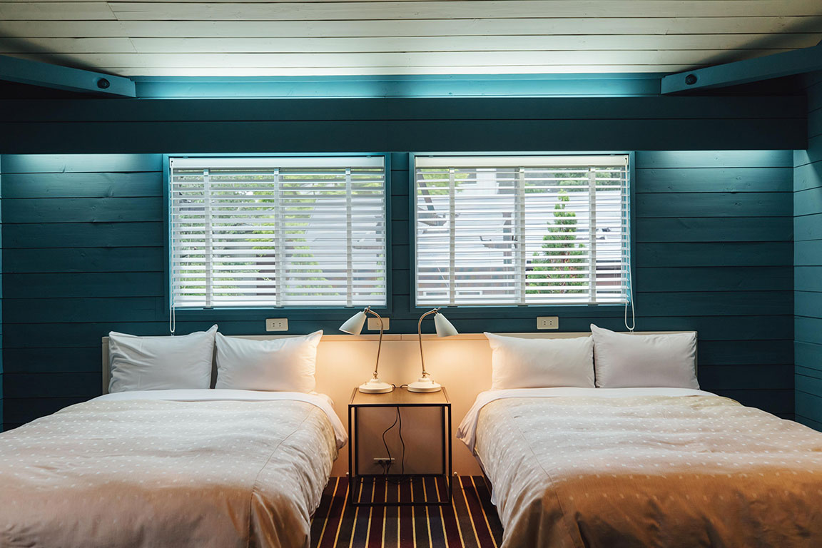 Chateraise Ski Valley Koumi in Japan - two beds in a room with wooden walls.