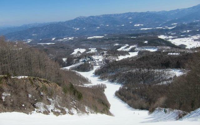 Ski resort at Chateraise Ski Valley Koumi in Japan, showcasing a chalet, snow-covered slopes, and winter sports activities in a mountainous backdrop.