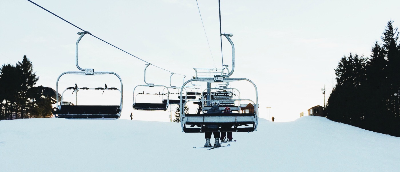 Ski lift at Brimacombe in Orono, Ontario, with skier in action. A typical winter sports scene at a ski resort complete with a passing snowmobile.