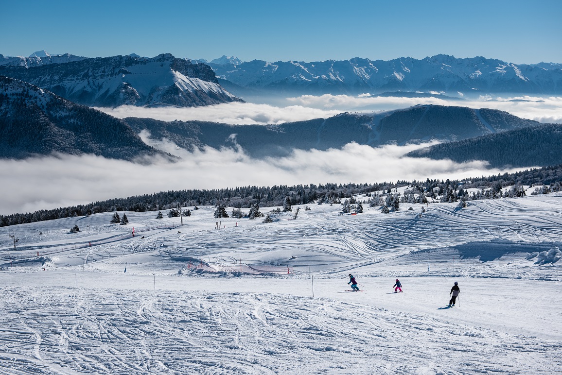 Aillon-le-Jeune in France - a group of people skiing down a snowy slope.