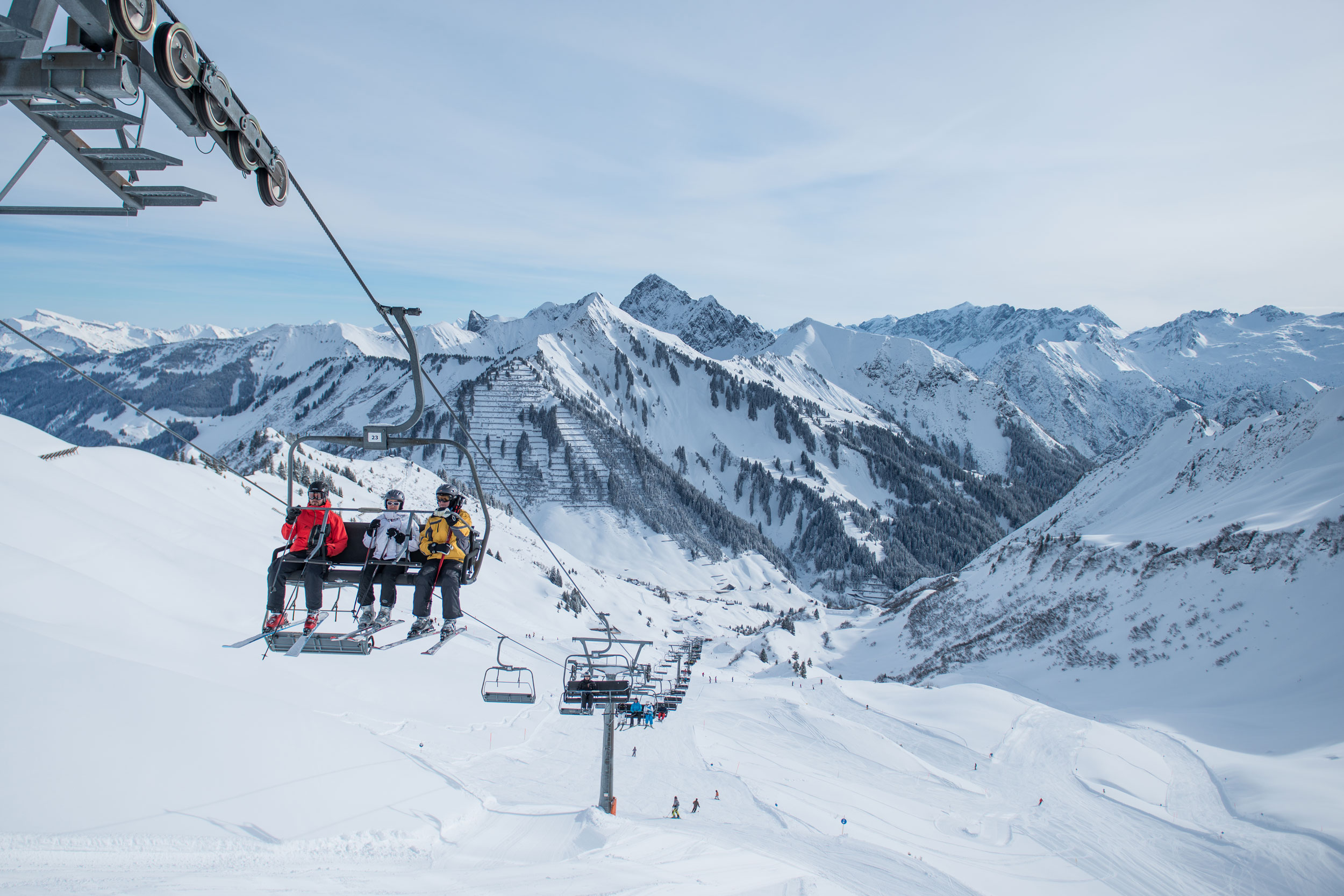 Faschina in Austria - two people sitting on a ski lift in the snow.
