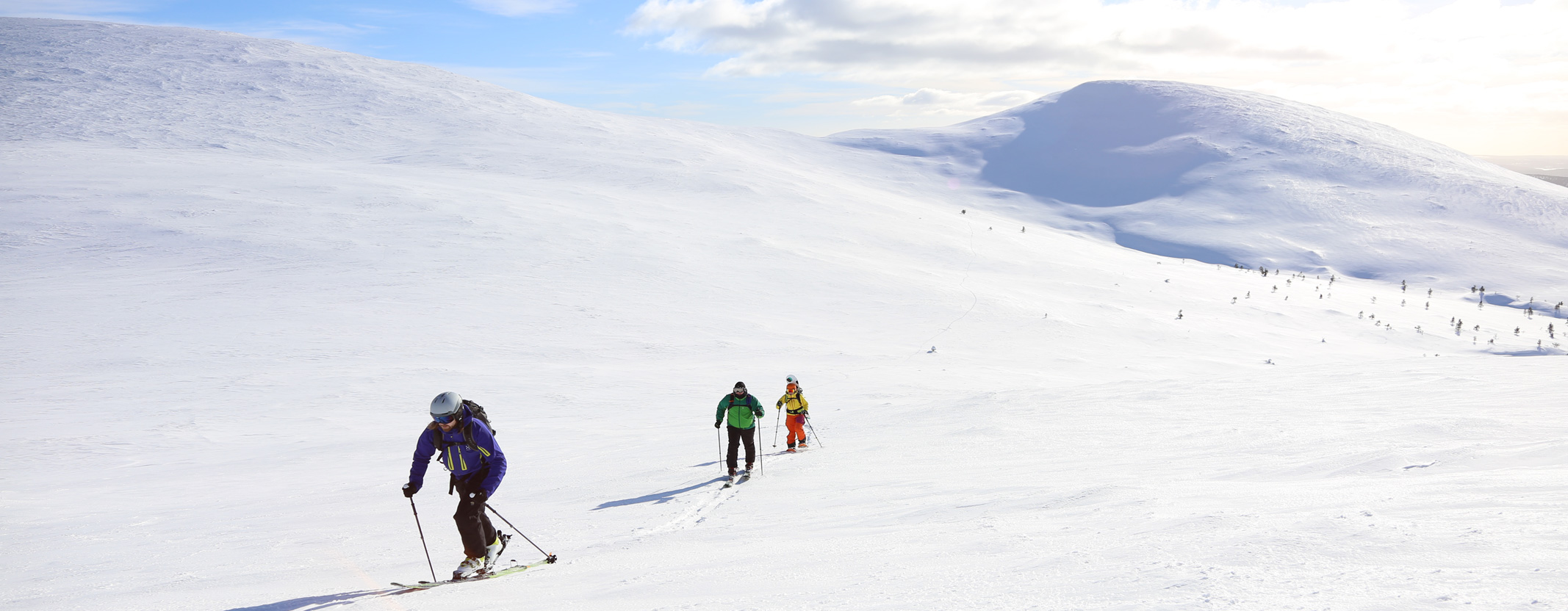 Pallas in Finland - a group of people skiing down a snow covered mountain.