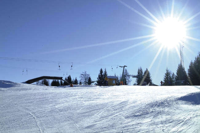 Simonhöhe in Austria - a person on a snowboard going down a hill.