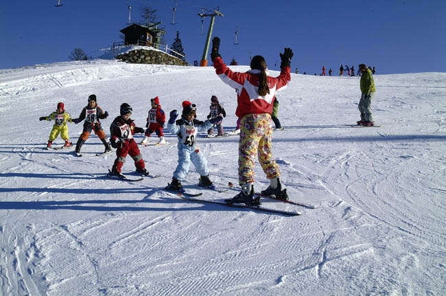 Simonhöhe in Austria - a group of people skiing down a snow covered hill.
