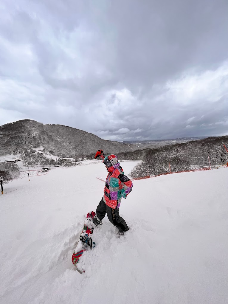 Kanazawa Municipal in Japan - a person riding a snowboard down a snow covered slope.