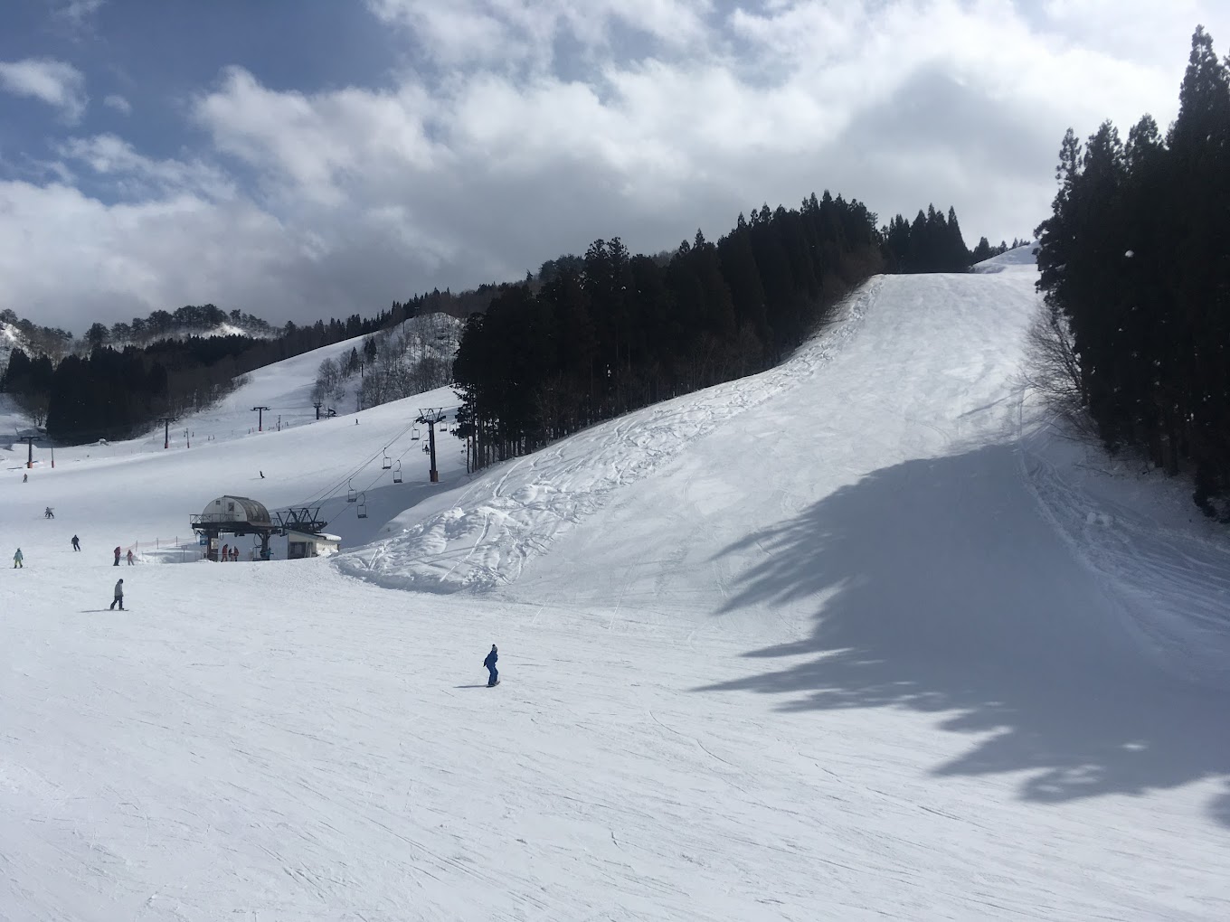 Yuzawa Park in Japan - a group of people skiing down a snow covered slope.