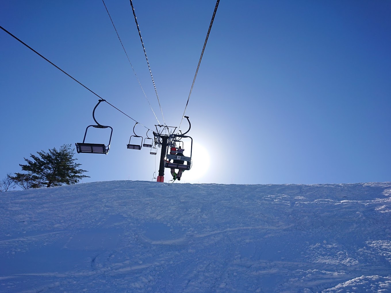 Yuzawa Park in Japan - a ski lift going up a snowy hill.