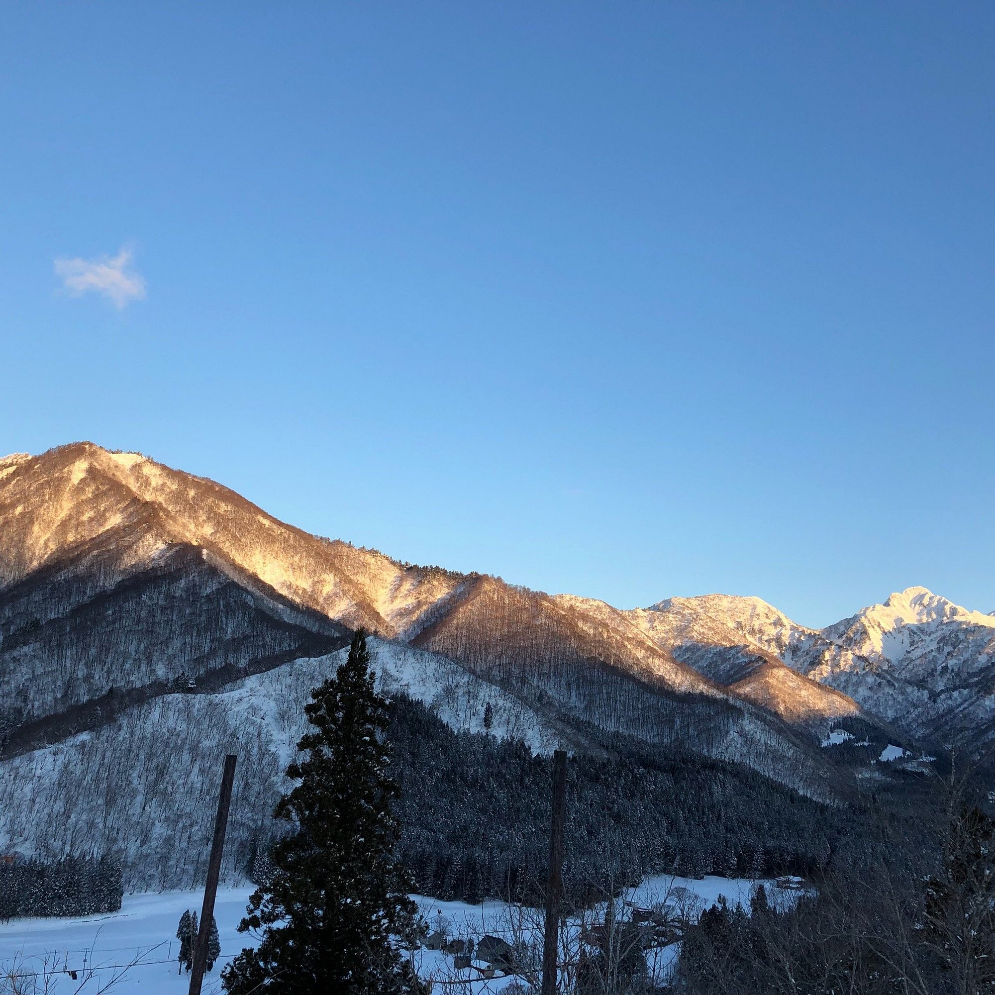 Yuzawa Park in Japan - the sun is shining on the mountains in the distance.
