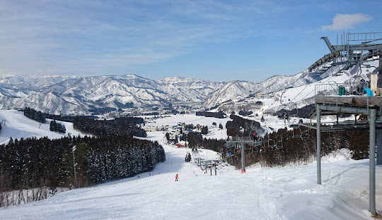 Yuzawa Park in Japan - a ski lift going down a snowy slope.