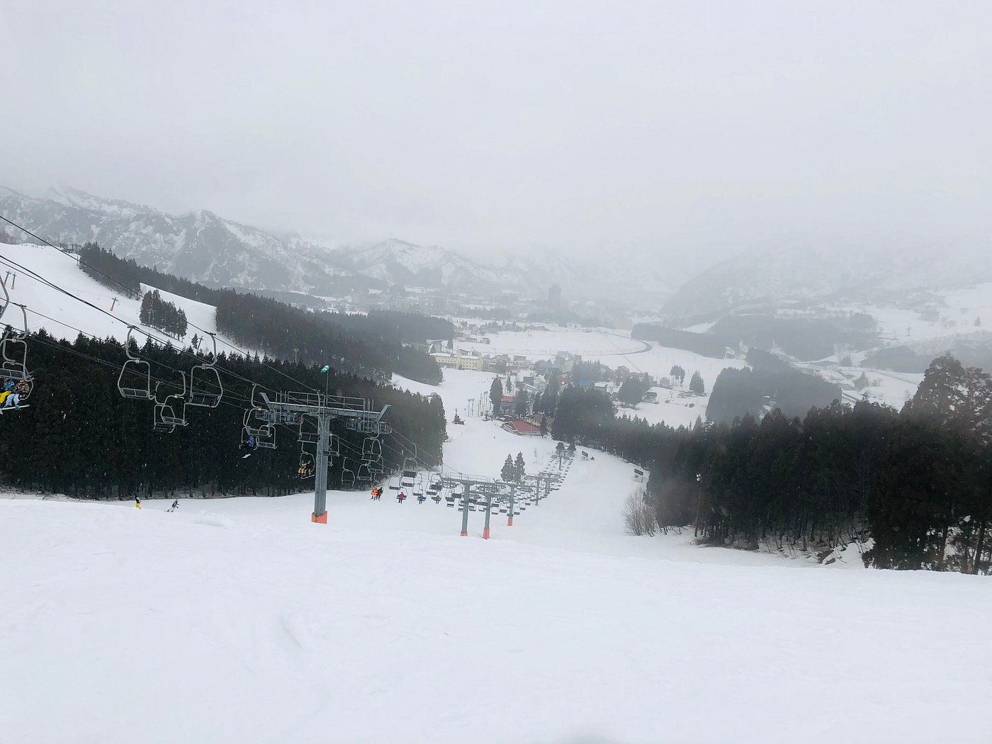 Yuzawa Park in Japan - a snow covered ski slope with trees in the background.
