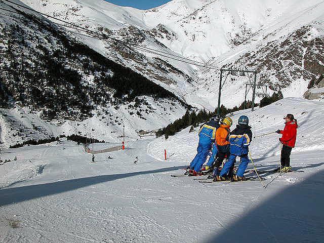Vall de Núria in Spain - a group of people skiing down a snow covered mountain.