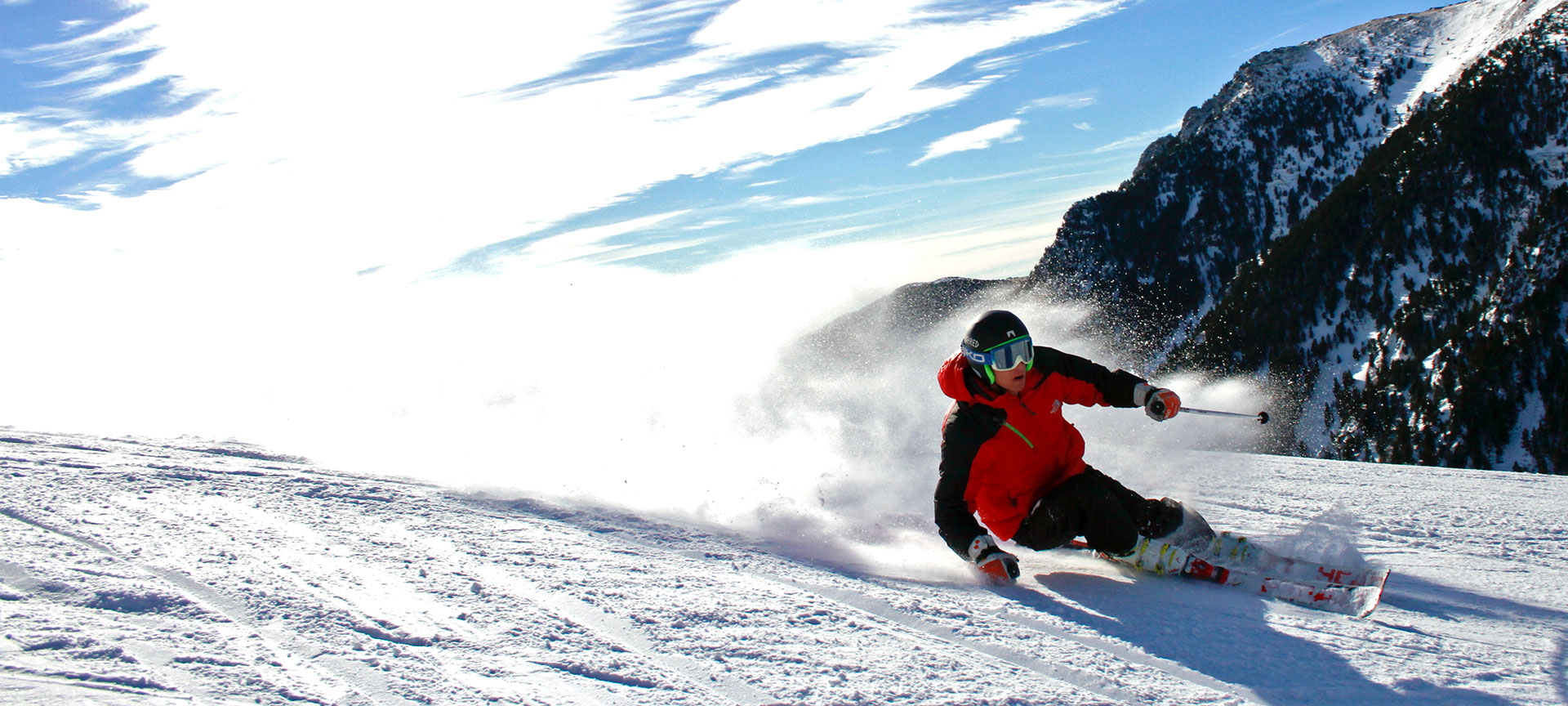Vall de Núria in Spain - a man riding a snowboard down a snow covered slope.