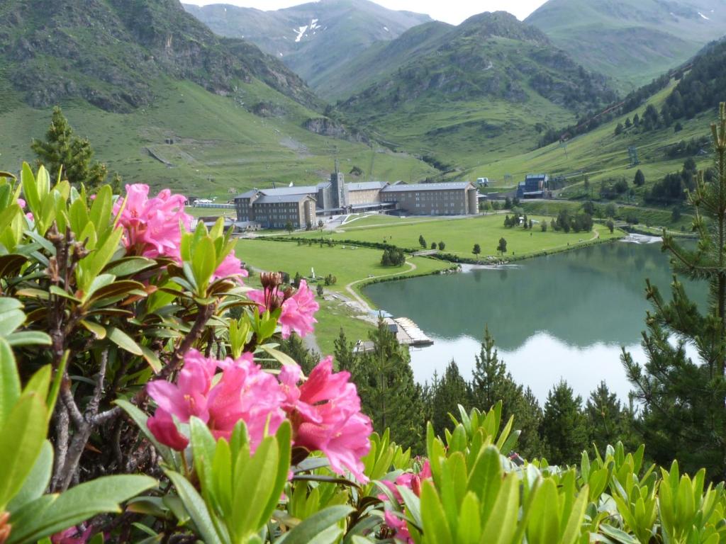 Vall de Núria in Spain - a lake surrounded by mountains and flowers.