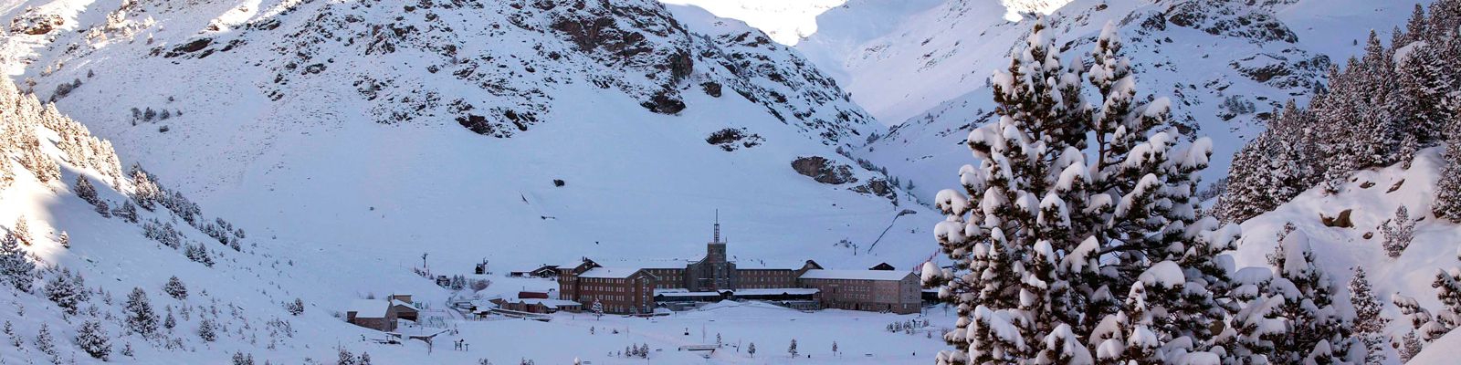 Vall de Núria in Spain - a snow covered mountain with a house in the middle.