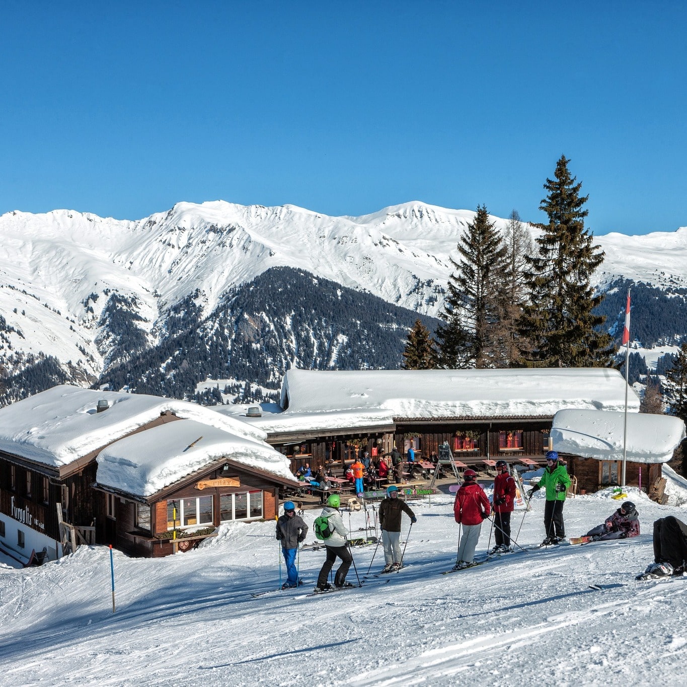 La Forclaz in Switzerland - a group of people skiing down a snowy hill.