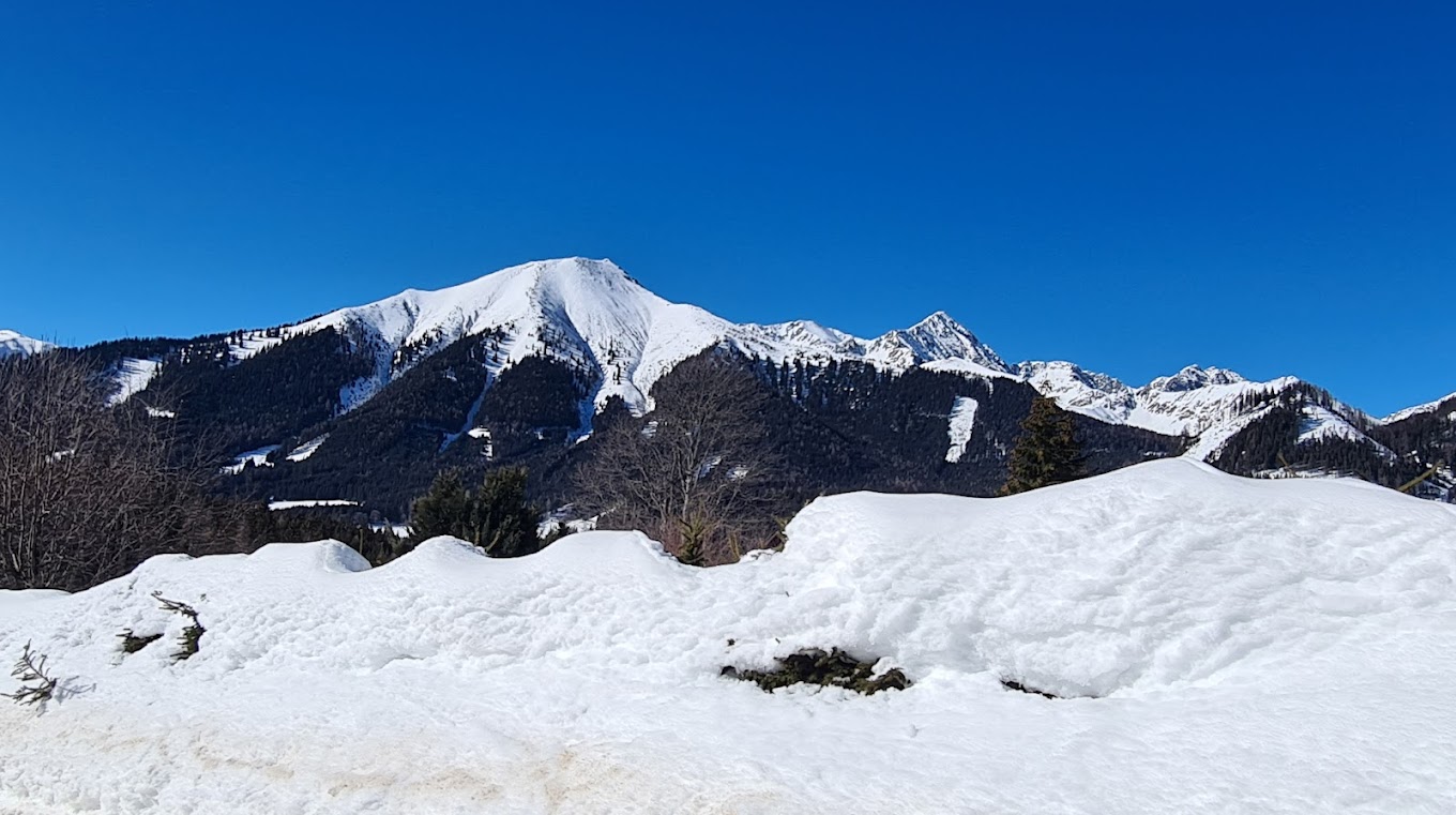 Hohentauern in Austria - a snow covered mountain with a clear blue sky.