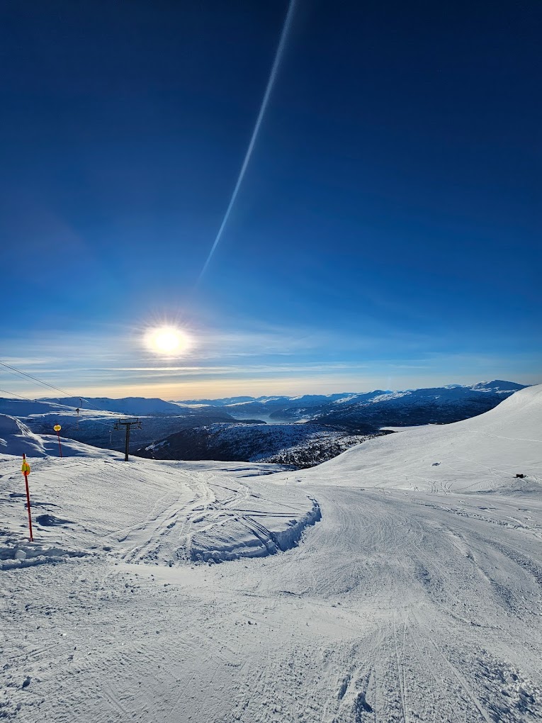 Stryn Vinterski in Norway - the sun is shining in the sky above a ski slope.