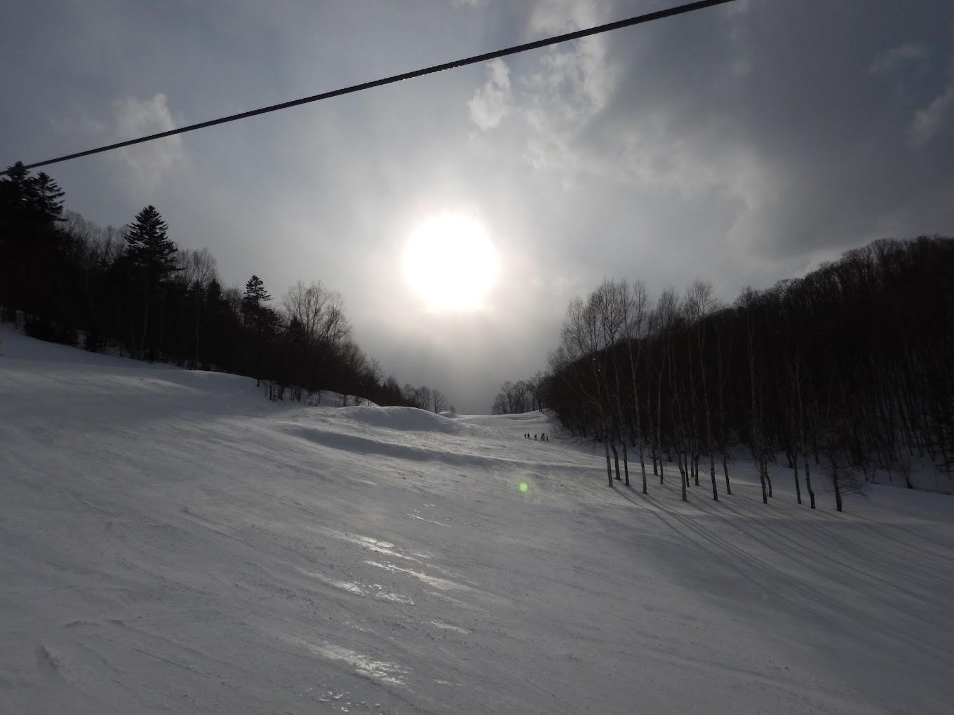 Engaru Rock Valley in Japan - the sun is shining through the clouds over a snowy slope.