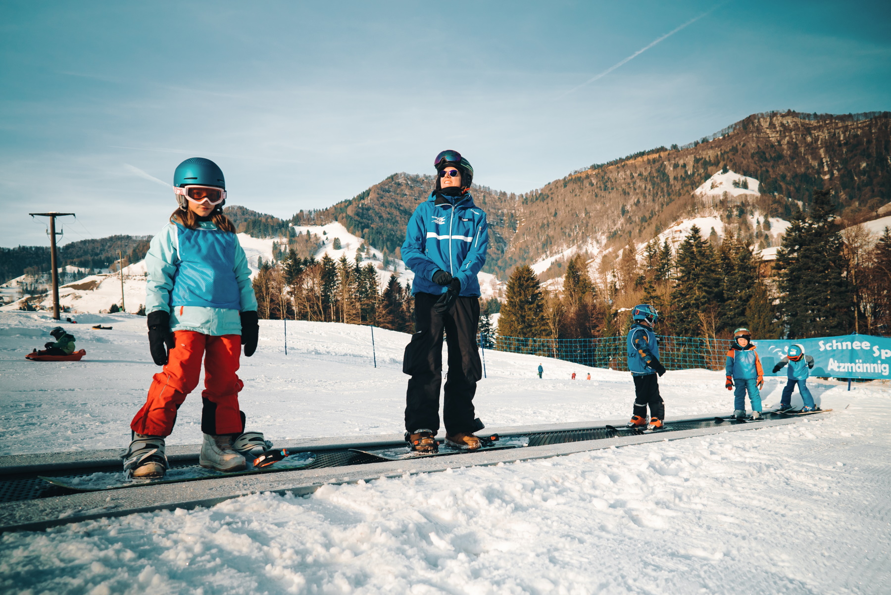 Atzmännig in Switzerland - a group of people standing on top of a snow covered slope.