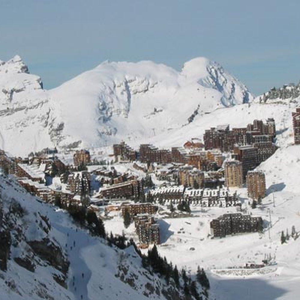 Les Plans d'Hotonnes in France - a view of a mountain town with snow covered mountains.
