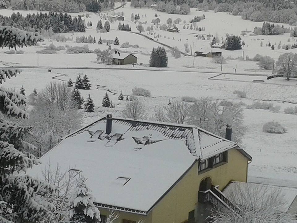 Le Noirmont in France - a yellow house in the middle of a snowy landscape.