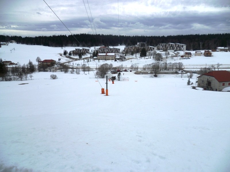 Le Noirmont in France - a snow covered field with houses in the background.